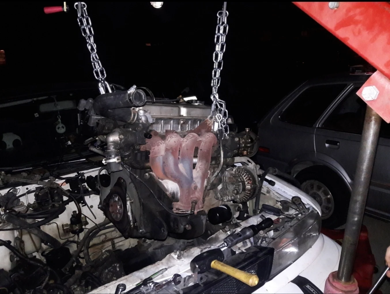 Engine suspended from a hoist during removal
